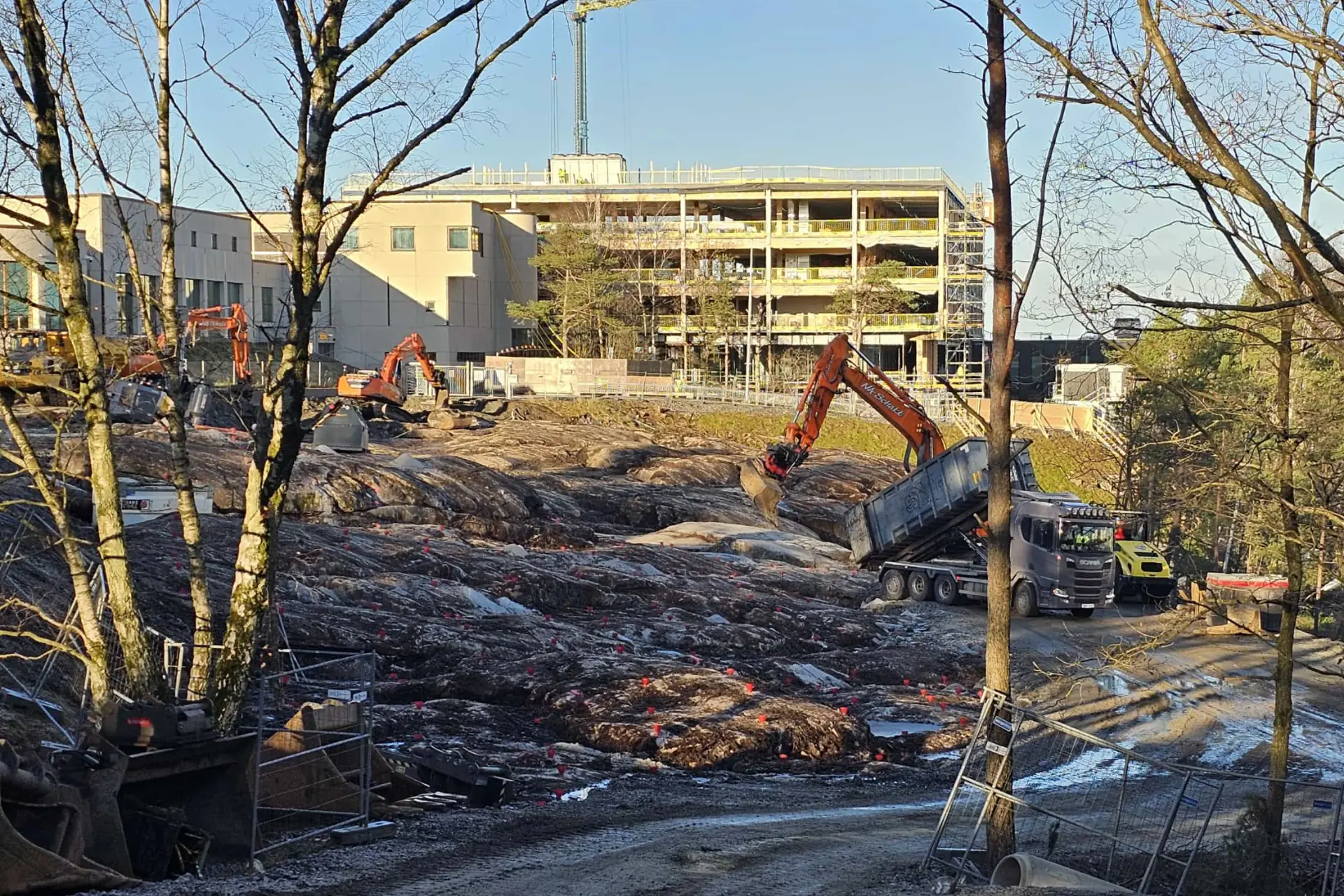 Grävmaskin och lastbil från NA Schakt på byggarbetsplats